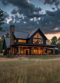 a large house sitting on top of a lush green field next to tall grass and trees