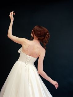 a woman in a white dress is pointing at something