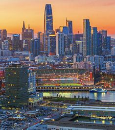 the city skyline is lit up at night, with many tall buildings in the background