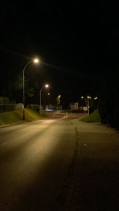 an empty street at night with lights on and no one in the dark around it