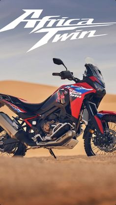 a red and black motorcycle parked in the desert