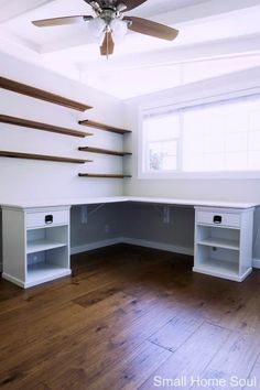 an empty room with some shelves and a ceiling fan