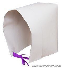 a white paper bag with purple ribbon tied to it's side and the top half open