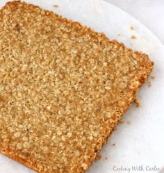 a close up of a piece of bread on a plate with crumbled toppings