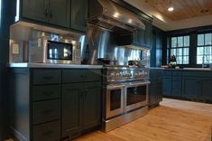 a large kitchen with stainless steel appliances and wood flooring is pictured in this image