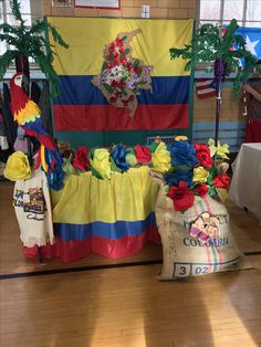 the table is decorated with colorful flowers and decorations for an event or celebration in front of a large flag