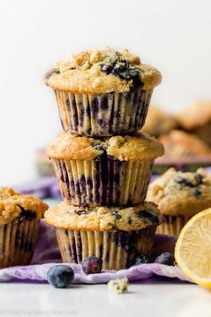 blueberry muffins stacked on top of each other next to lemon wedges