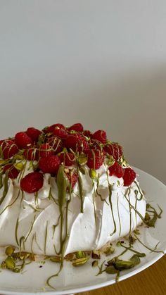 a cake covered in whipped cream and strawberries on top of a white platter