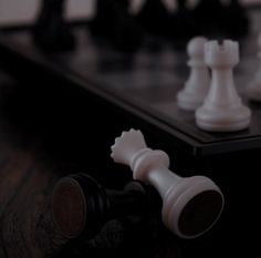 a chess board with white pieces on it and one black piece in the foreground