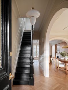 an entry way leading to a living room and dining room area with wood flooring