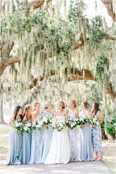 a group of women standing next to each other under a tree