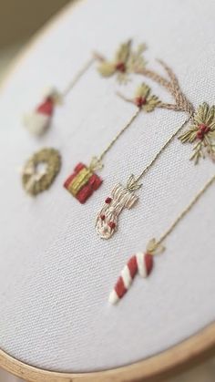 a close up of a cross stitch pattern on a white piece of cloth with christmas decorations