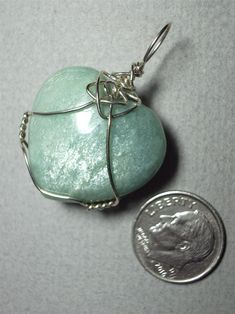 Amazonite Heart Pendant Wire Wrapped in .925 Sterling Silver Round Wire This beautiful uplifting blue-green stone heart also displays adularescence similar to moonstone. It wears best with green, red, orange and medium to dark shades of blue clothing, and quite attractive with pastels. Nicely worn with most colors, but avoid wearing with similar light blue-green colored clothing; A consistent color, heart shape, and domed surface make this stone well suited to a purist view. Patterns of adulares Turquoise Aventurine Jewelry As A Gift, Aventurine Turquoise Jewelry For Gifts, Spiritual Heart Cut Jewelry For Healing, Turquoise Aventurine Jewelry For Gifts, Green Double Heart Jewelry For Gift, Unique Heart Pendant Jewelry For Healing, Turquoise Aventurine Jewelry Gift, Handmade Green Heart Cut Jewelry, Silver Aventurine Jewelry As A Gift