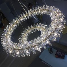 a chandelier with lights hanging from it's sides in a living room