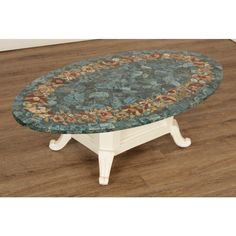 a round table with a floral design on it's top sitting on a hard wood floor