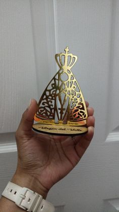 a person holding up a golden trophy in front of a white door with an ornate design on it