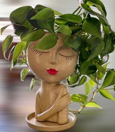 a ceramic figurine sitting on top of a table next to a potted plant