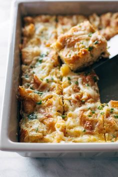 a casserole dish with meat and cheese in it being cut by a spatula