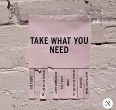 a pink sign that says, take what you need on the side of a brick wall