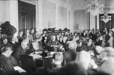 an old black and white photo of people sitting at desks in a large room