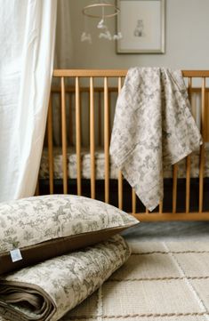 a baby crib with two blankets on top of it next to the crib