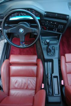 the interior of a car with red leather seats and steering wheel, including an automatic