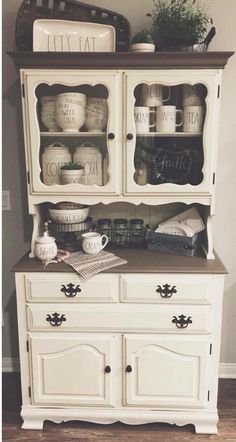 an old china cabinet is painted white with black lettering on the front and bottom shelves