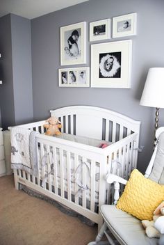 a baby's room with gray walls and pictures on the wall