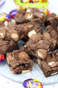 chocolate brownies with marshmallows are on a plate next to easter eggs