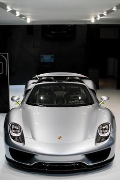 a silver sports car on display in a showroom