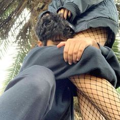 a man in fishnet stockings is hugging a woman