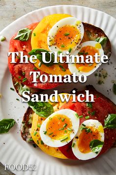 the ultimate tomato sandwich with hard boiled eggs and spinach on top is shown here