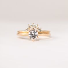 a gold ring with a white diamond in the center and two smaller diamonds on each side