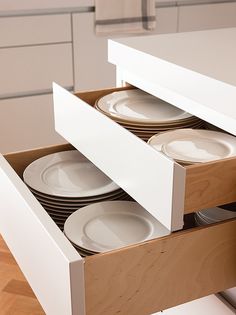 an open drawer with plates in it