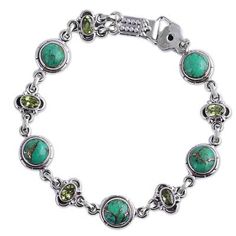 The glistening peridot gemstones are appealing in the design of this handcrafted bracelet from Neeru Goel of India. Combined with green composite turquoise stones amidst a sterling silver setting the green hues complement each other to create an exquisite piece. The piece fastens with a box hook clasp that features a dot pattern. Green Peridot Gemstone Beads Jewelry, Green Peridot Jewelry With Gemstone Beads, Green Multi-stone Jewelry For May Birthstone, Bohemian Green Jewelry With Gemstone Accents, Green Peridot Bohemian Jewelry, Green Bohemian Peridot Jewelry, Bohemian Green Peridot Jewelry, Green Bohemian Beaded Bracelets With Stones, Bohemian Green Beaded Bracelets With Stones