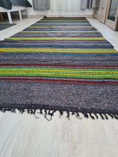 a multicolored rug with fringes on the floor