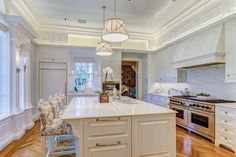 a large kitchen with white cabinets and an island