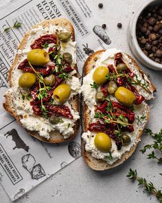 two pieces of bread topped with olives and goat cheese