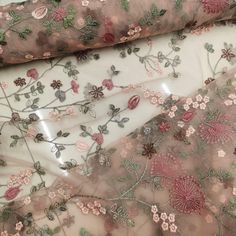 sheer fabric with flowers and leaves on it, as well as an embroidered mesh material