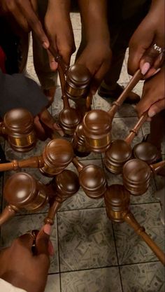 a group of people standing around each other with wooden mallets in front of them