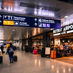 people are walking through an airport with their luggage