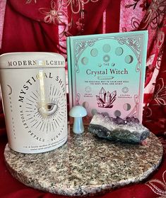 the crystal witch kit is sitting on a marble table next to a book and candle