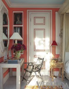 a room with red walls and white trim on the door is decorated in black and white