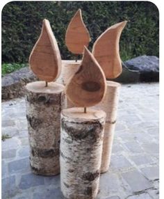 three pieces of wood sitting on top of each other in front of some rocks and trees