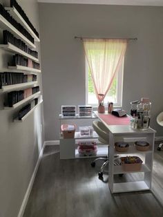 a room with a desk and shelves filled with books