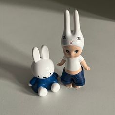 two toy rabbits sitting next to each other on a table