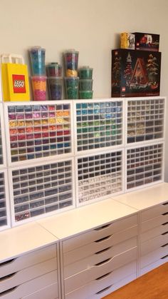 several plastic bins are stacked on top of each other in front of a wall