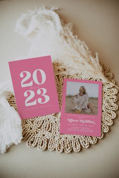 two pink cards with the numbers twenty and thirty on them sitting on a doily