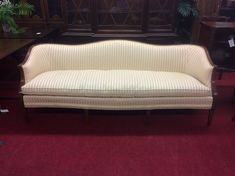 a white couch sitting on top of a red carpeted floor