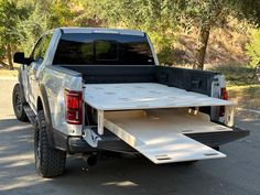 a pickup truck with its bed open on the road